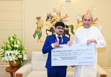 Chief Minister Shri Naveen Patnaik  handing over cheques to Sri Pramod Bhagat and Sri Soundarya Pradhan on their performance in the Asian Para Games at Naveen Niwas
